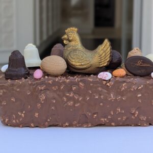 cake de paques , vanille aux notes d'agrumes, confits (orange et citron) aux pepite de chocolat et aux éclats de noisette. enrobé chocolat lait aux éclats d'amande grillées